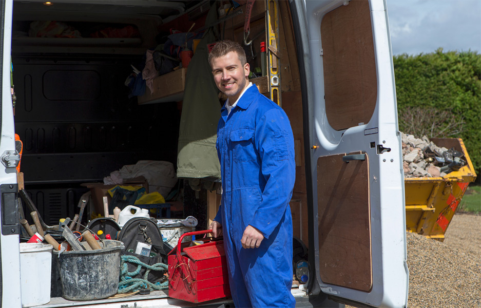 man standing beside a van smiling