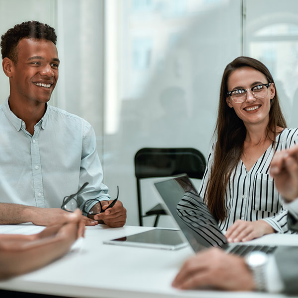 young and happy coworkers smiling and having a meeting in the office