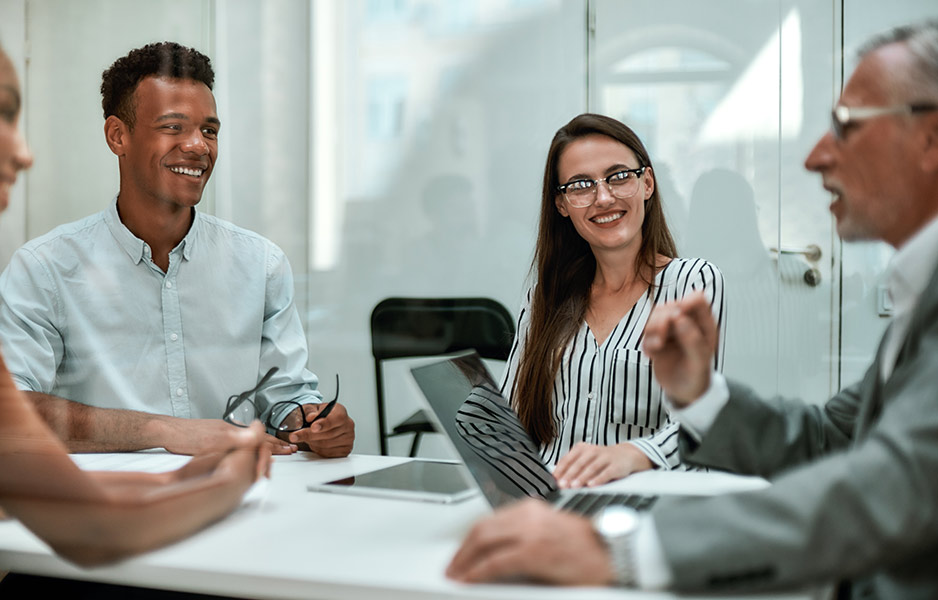 young and happy coworkers smiling and having a meeting in the office